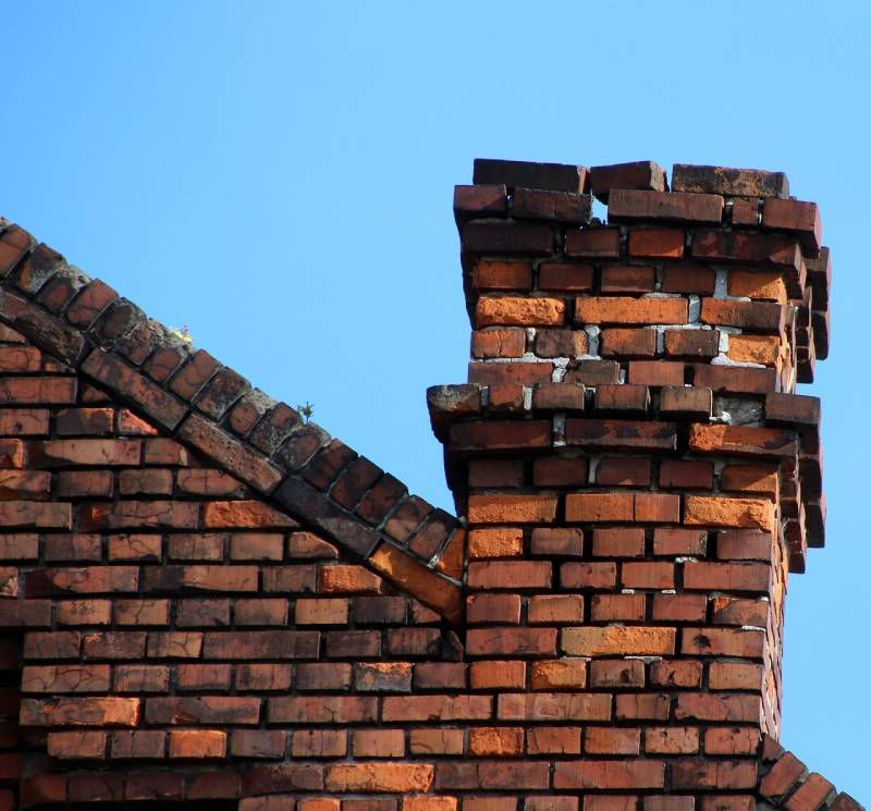Damaged chimney on an Riviera Beach home showing cracks and missing mortar